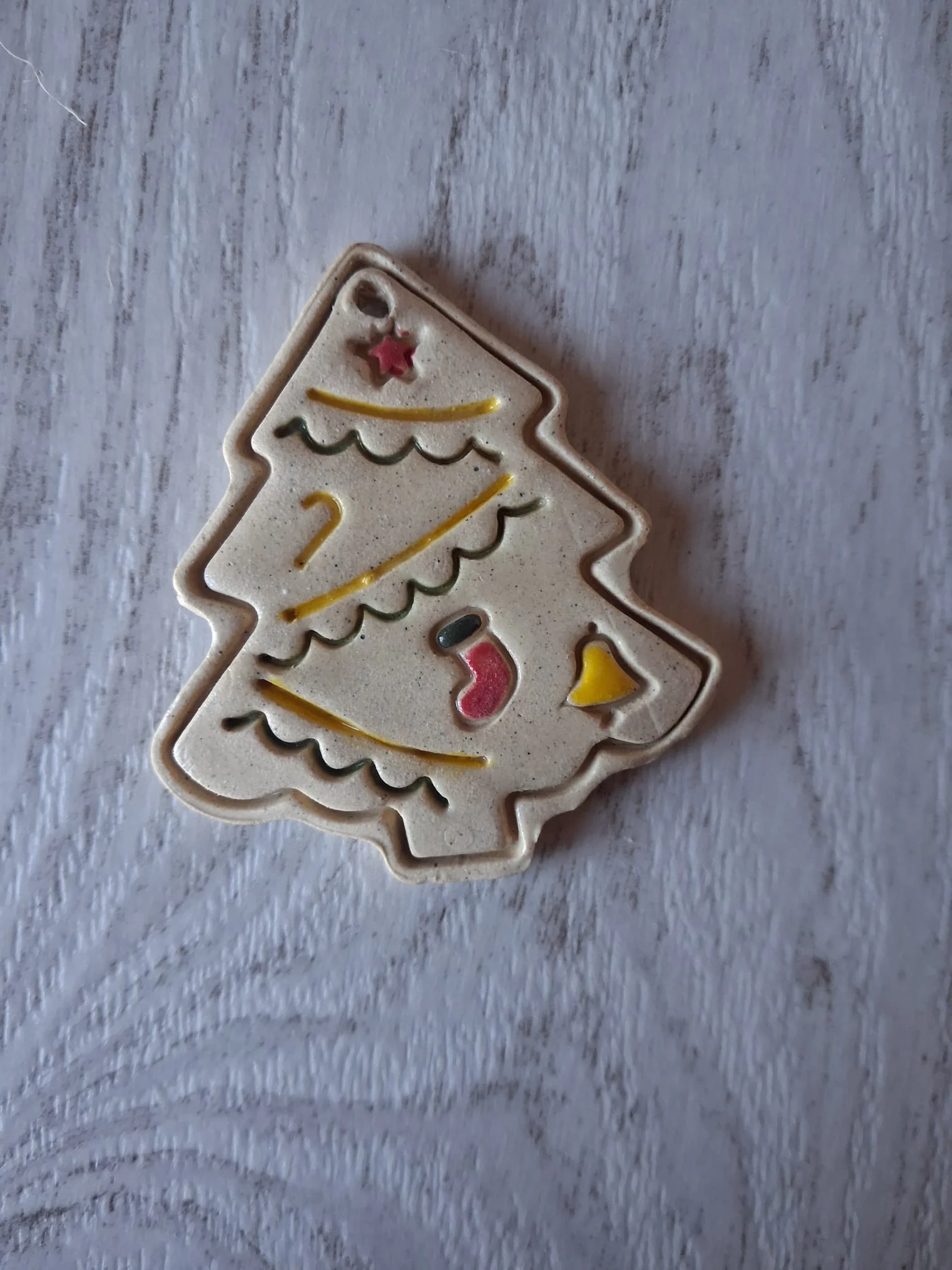 Adorno de Navidad de cerámica con forma de abeto decorado con guirnaldas verdes y amarillas, estrella roja, calcetín y campana, pintado a mano en Valladolid — CreArte