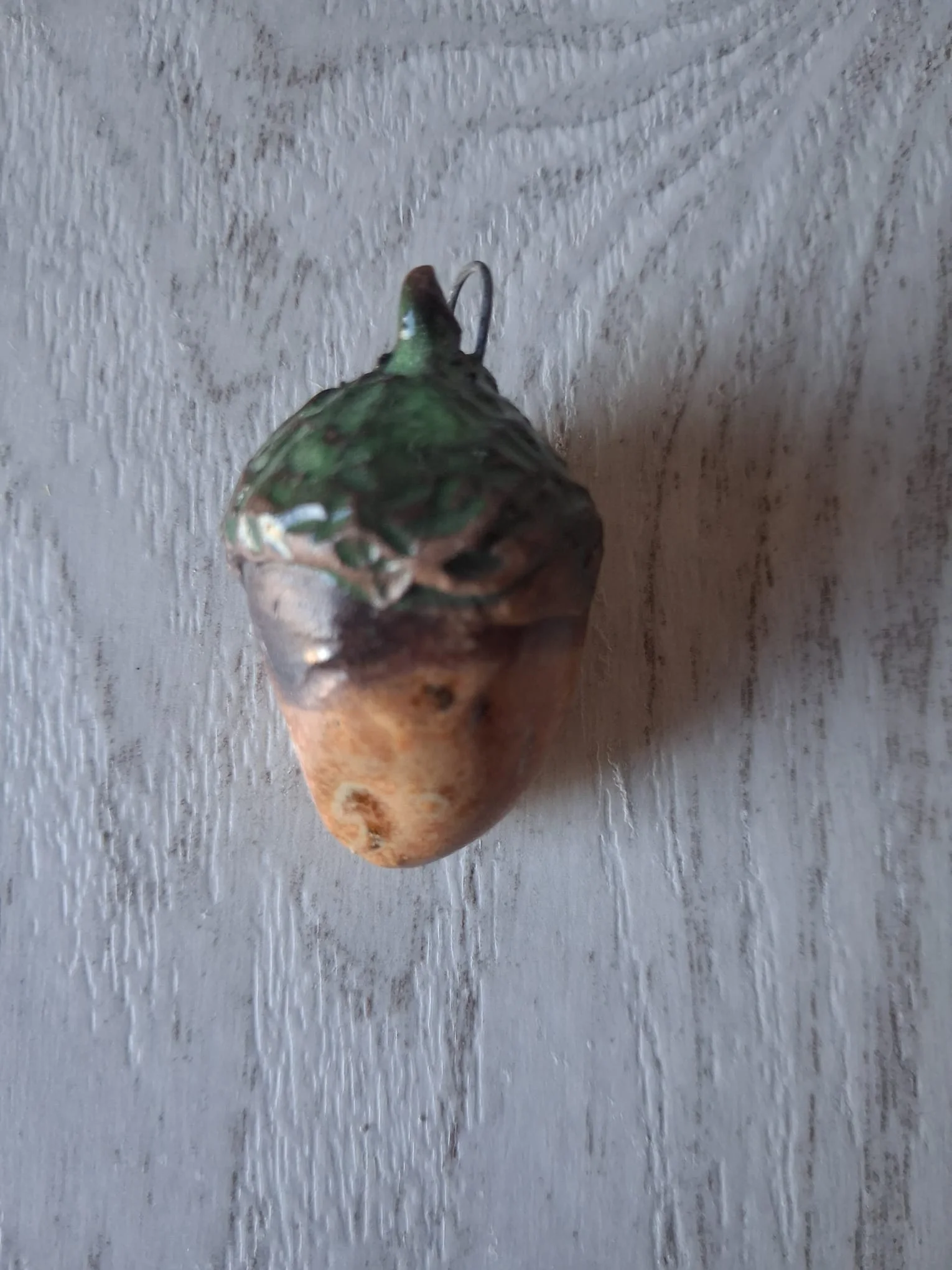 Adorno de Navidad de gres con forma de bellota de unos 4 cm, de capuchón verde brillante y cuerpo beige anaranjado, con anilla de alambre para colgar, esmaltado a mano en Valladolid — CreArte