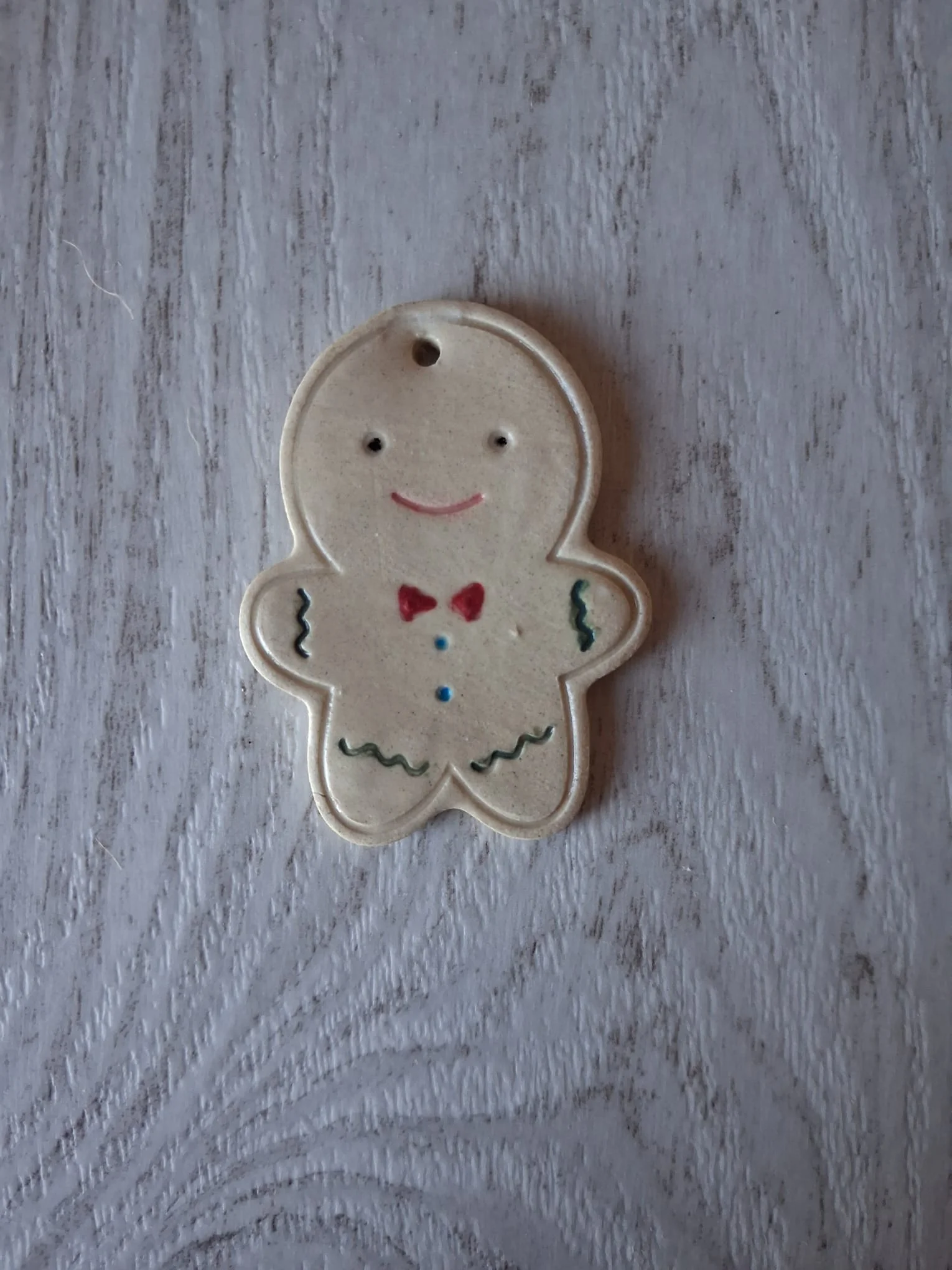 Adorno de Navidad de cerámica con forma de galleta de jengibre con pajarita roja, botones azules y adornos verdes, esmaltado a mano en Valladolid — CreArte