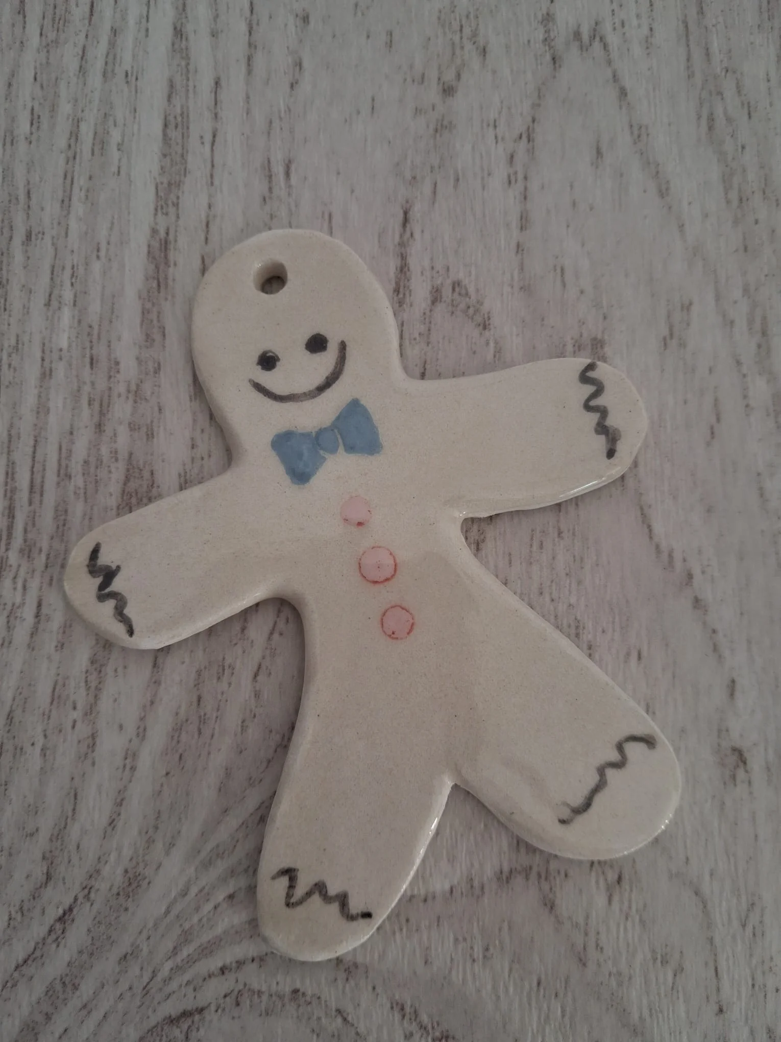 Adorno de Navidad de cerámica con galleta de jengibre blanca, pajarita azul, botones rosas y detalles negros, personalizable, pintado a mano en Valladolid — CreArte