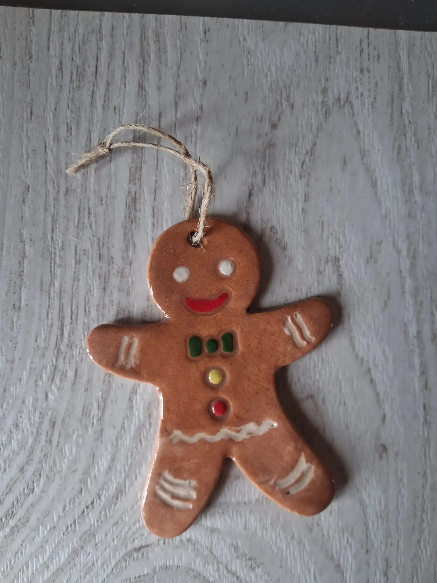 Adorno de Navidad de cerámica con hombre de jengibre marrón, pajarita verde y botones de colores, con cordel de yute, hecho a mano en Valladolid — CreArte