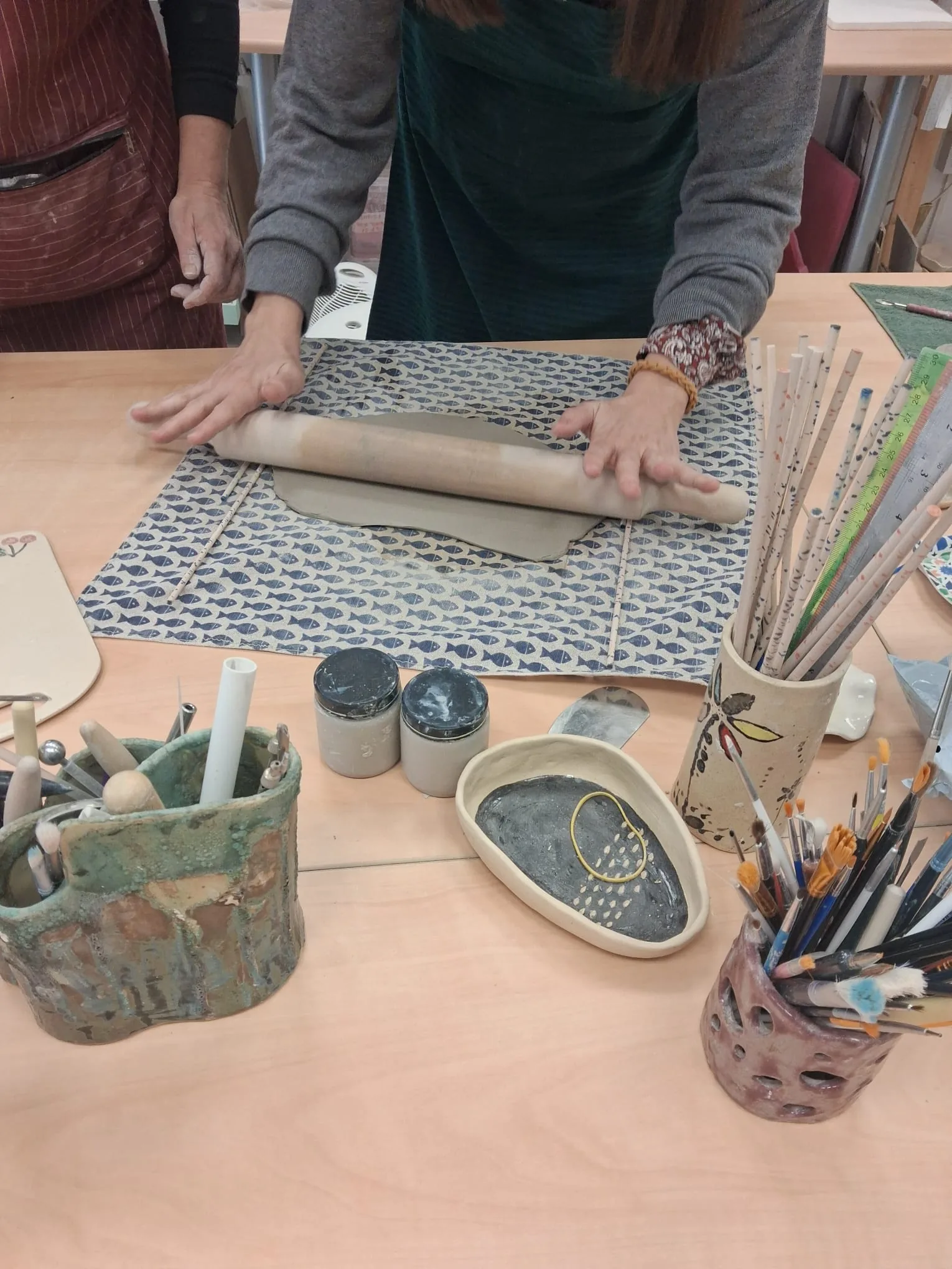 Alumna extendiendo una plancha de barro con rodillo en el taller de cerámica CreArte, Valladolid