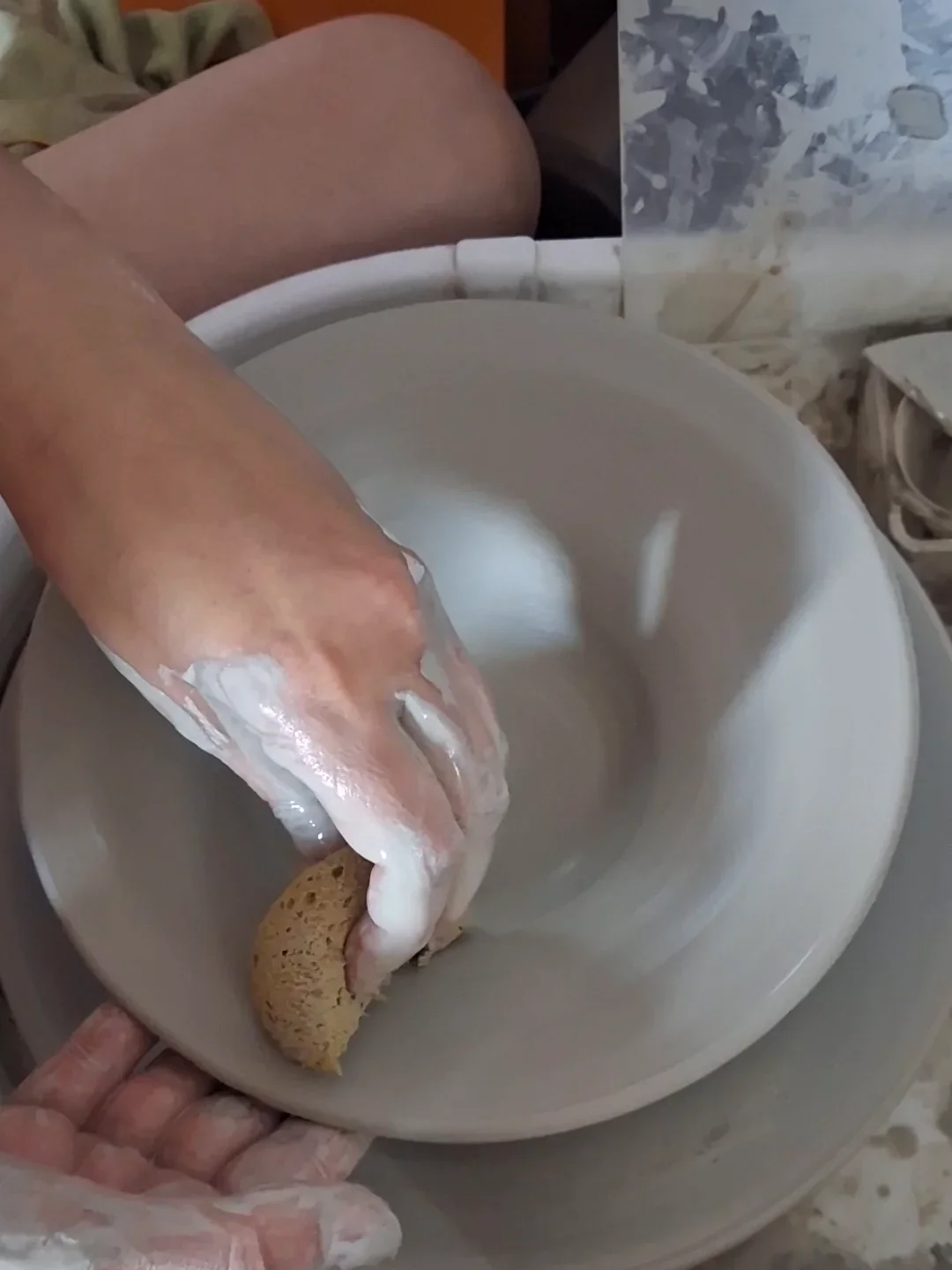 Manos modelando un cuenco de cerámica en el torno alfarero durante un taller puntual en Valladolid - CreArte