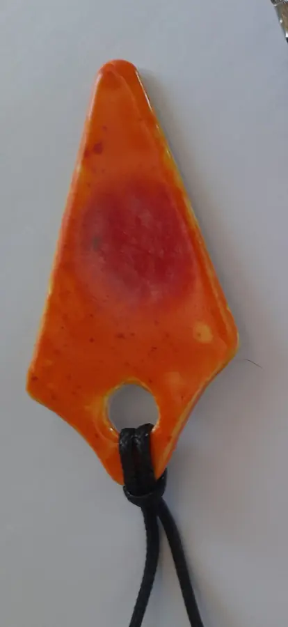 Colgante de cerámica naranja pico con agujero calado y manchas rojas, Colección Color, hecho a mano en Valladolid