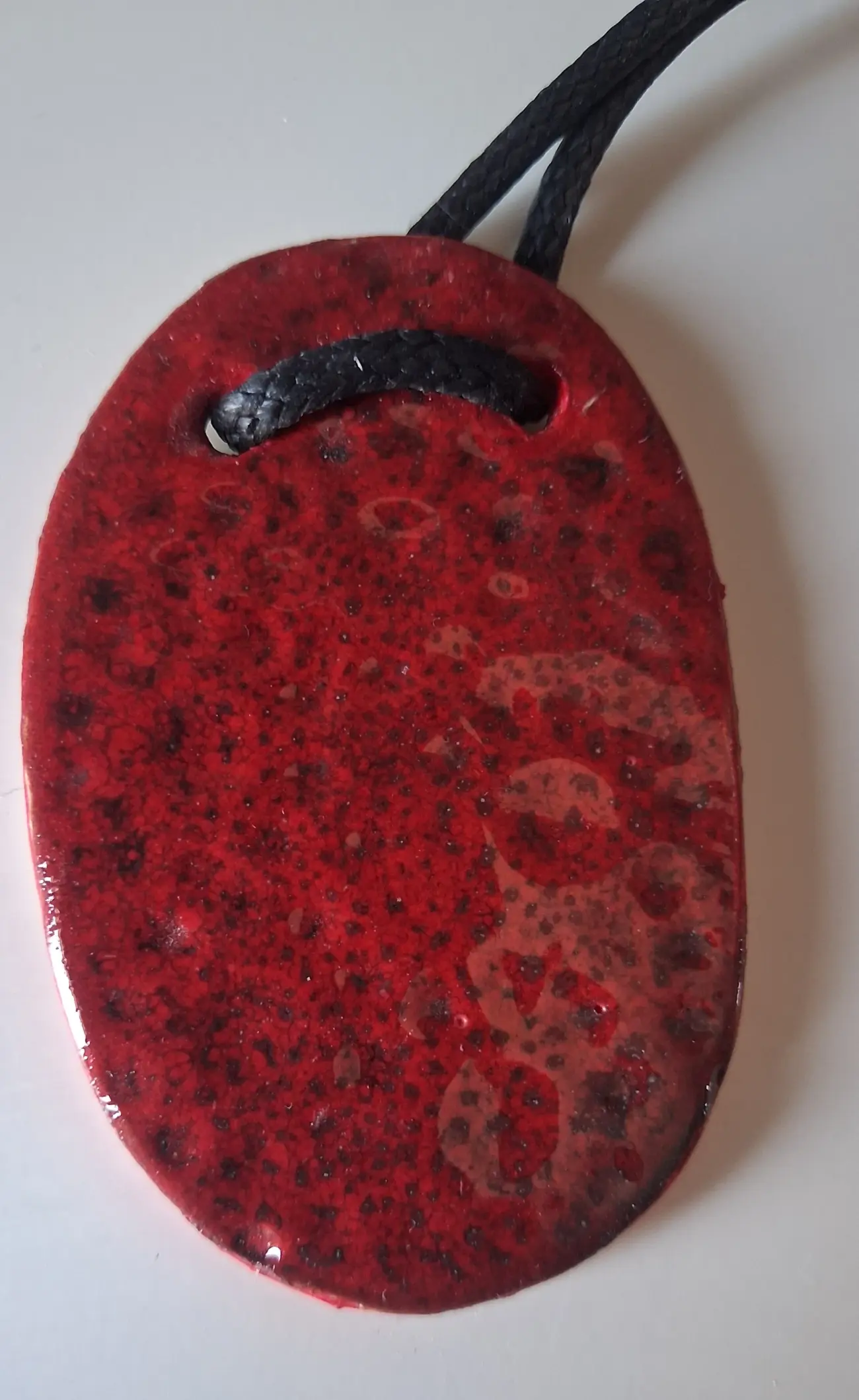 Colgante de cerámica ovalado rojo moteado con esmalte granulado, Colección Geométrica, taller CreArte Valladolid