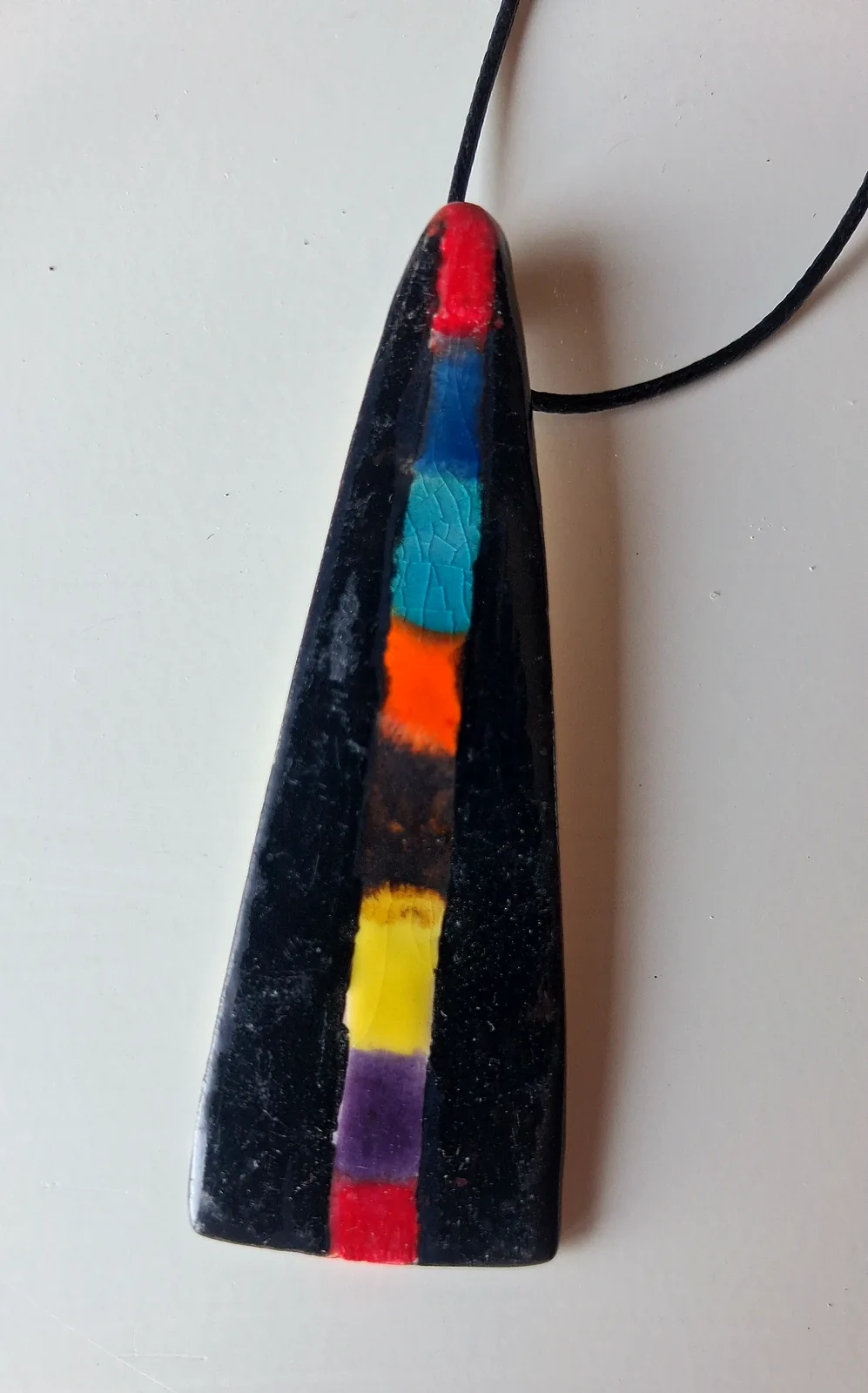 Collar de cerámica artesanal triangular en negro con banda central multicolor pintada a mano