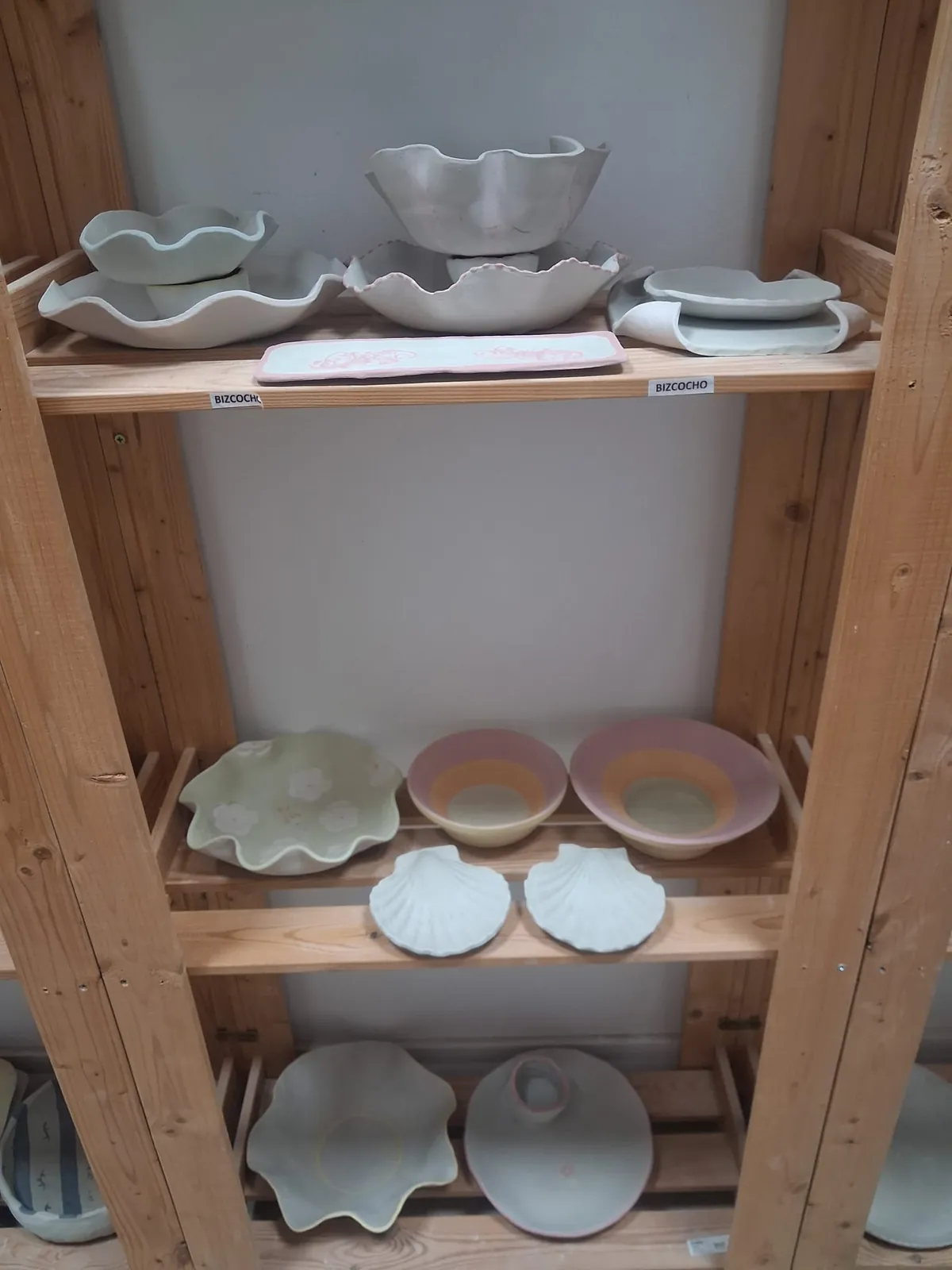 Estanterías del taller con piezas de cerámica en fase de bizcocho esperando su esmaltado y segunda cocción en CreArte Valladolid