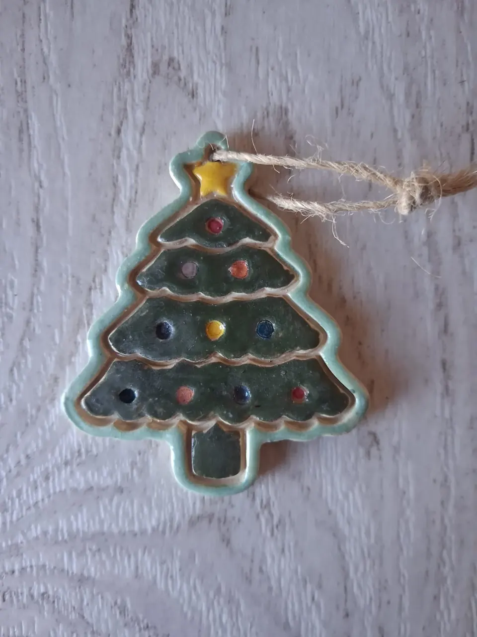Figura de Navidad de cerámica con forma de abeto verde esmaltado con borde turquesa, estrella amarilla en la copa y bolitas de colores, con cordel de yute para colgar, de unos 5-6 cm, hecha a mano en Valladolid — CreArte