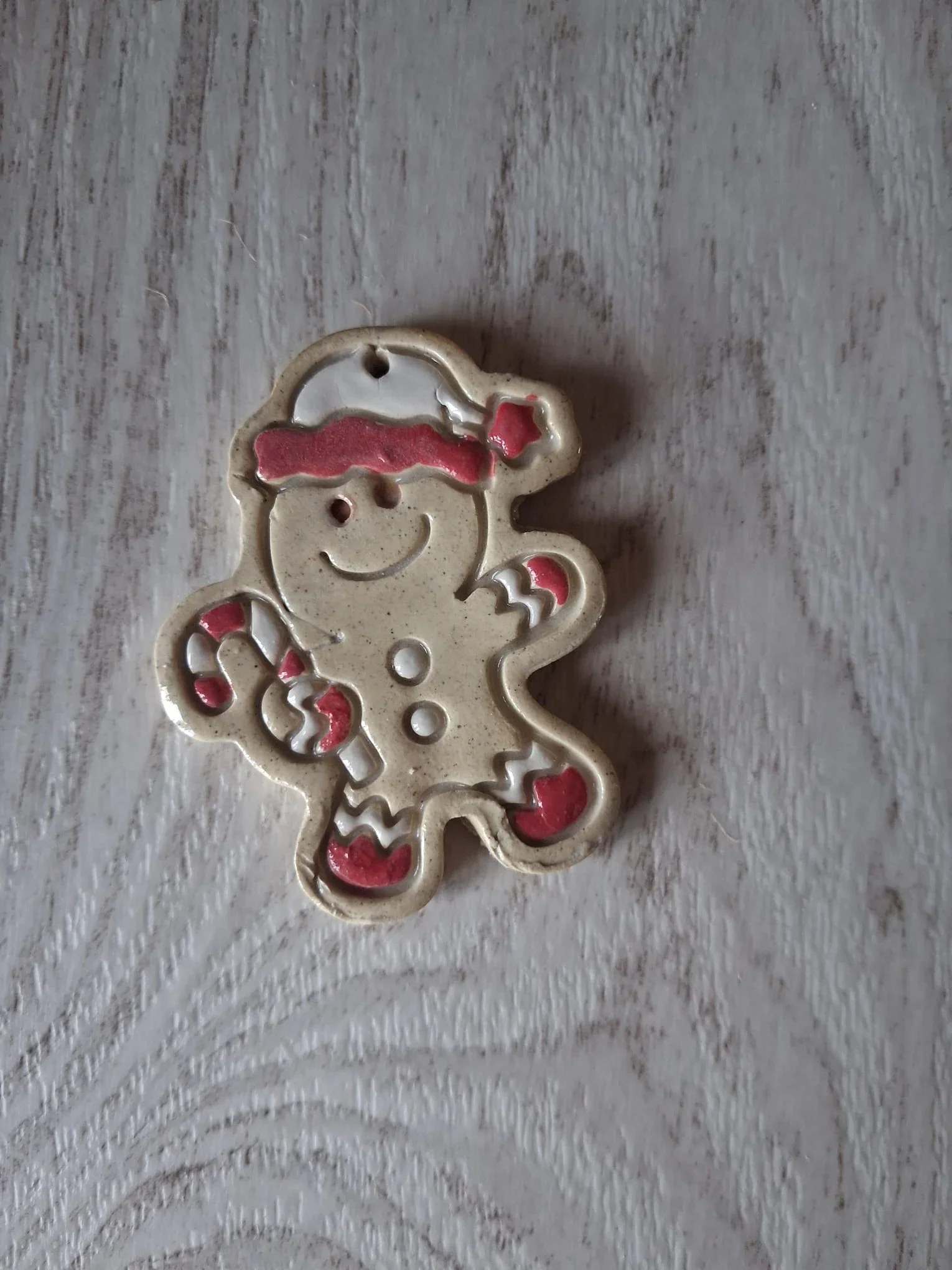 Figura de Navidad de cerámica con galleta de jengibre con gorro de Papá Noel rojo y blanco, sosteniendo un bastón de caramelo, con brazos y piernas de rayas rojas y blancas, hecha a mano en Valladolid — CreArte