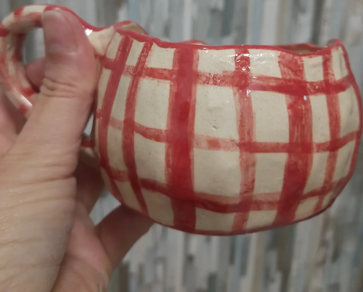 Taza de cerámica con estampado de cuadros rojos hecha en taller puntual de CreArte