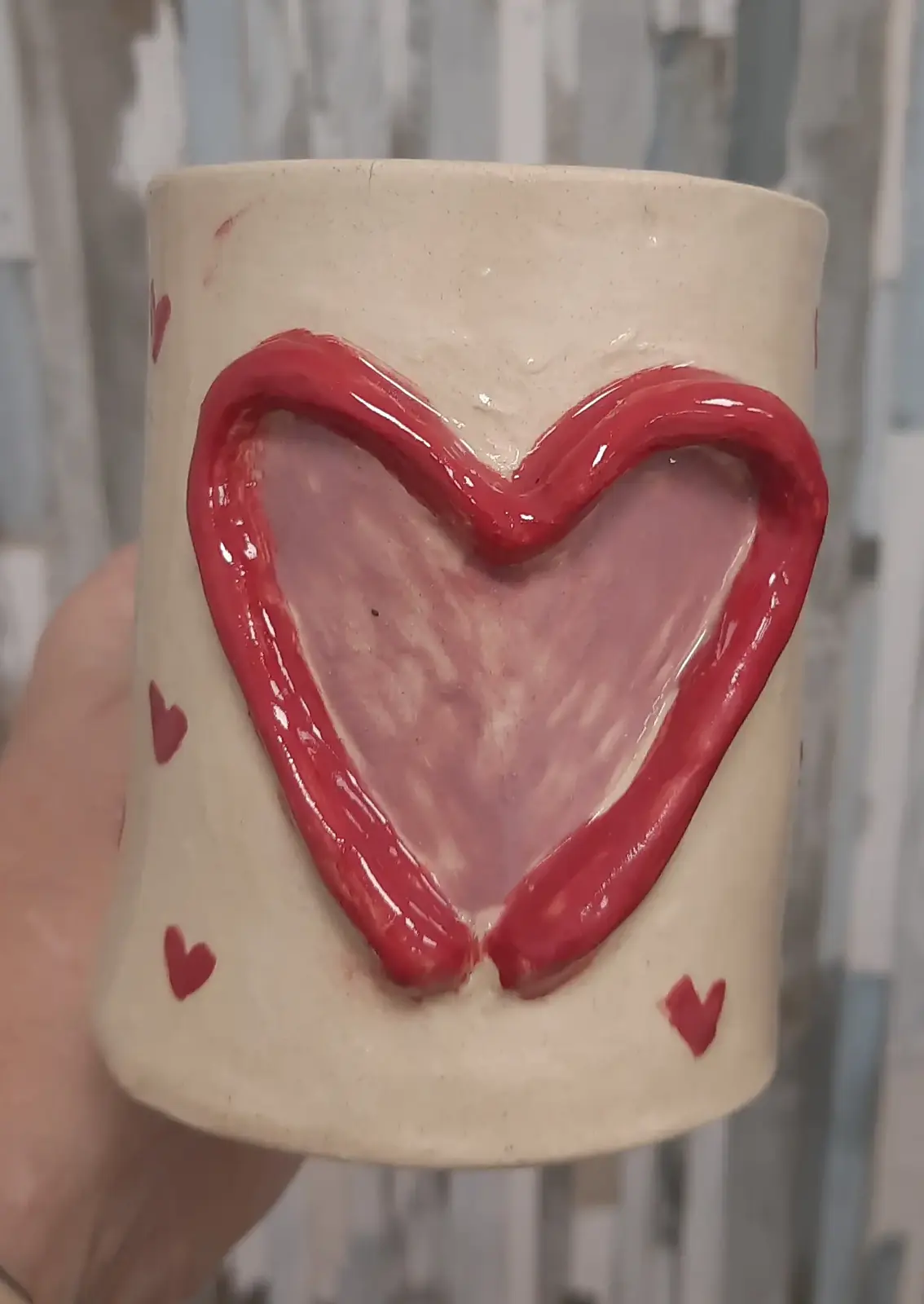 Taza de cerámica con corazón en relieve y pequeños corazones hecha en taller puntual de CreArte