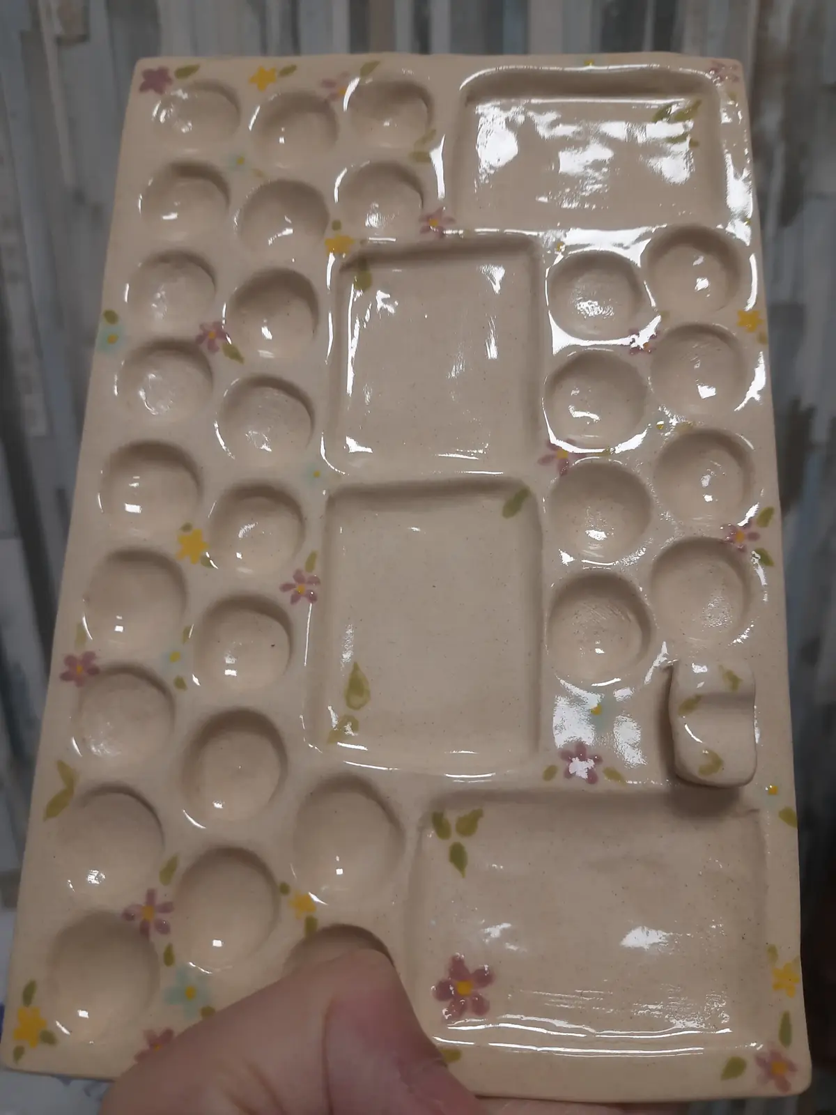 Paleta de cerámica con huecos para mezclar colores, decorada con florecitas, hecha en taller puntual de CreArte