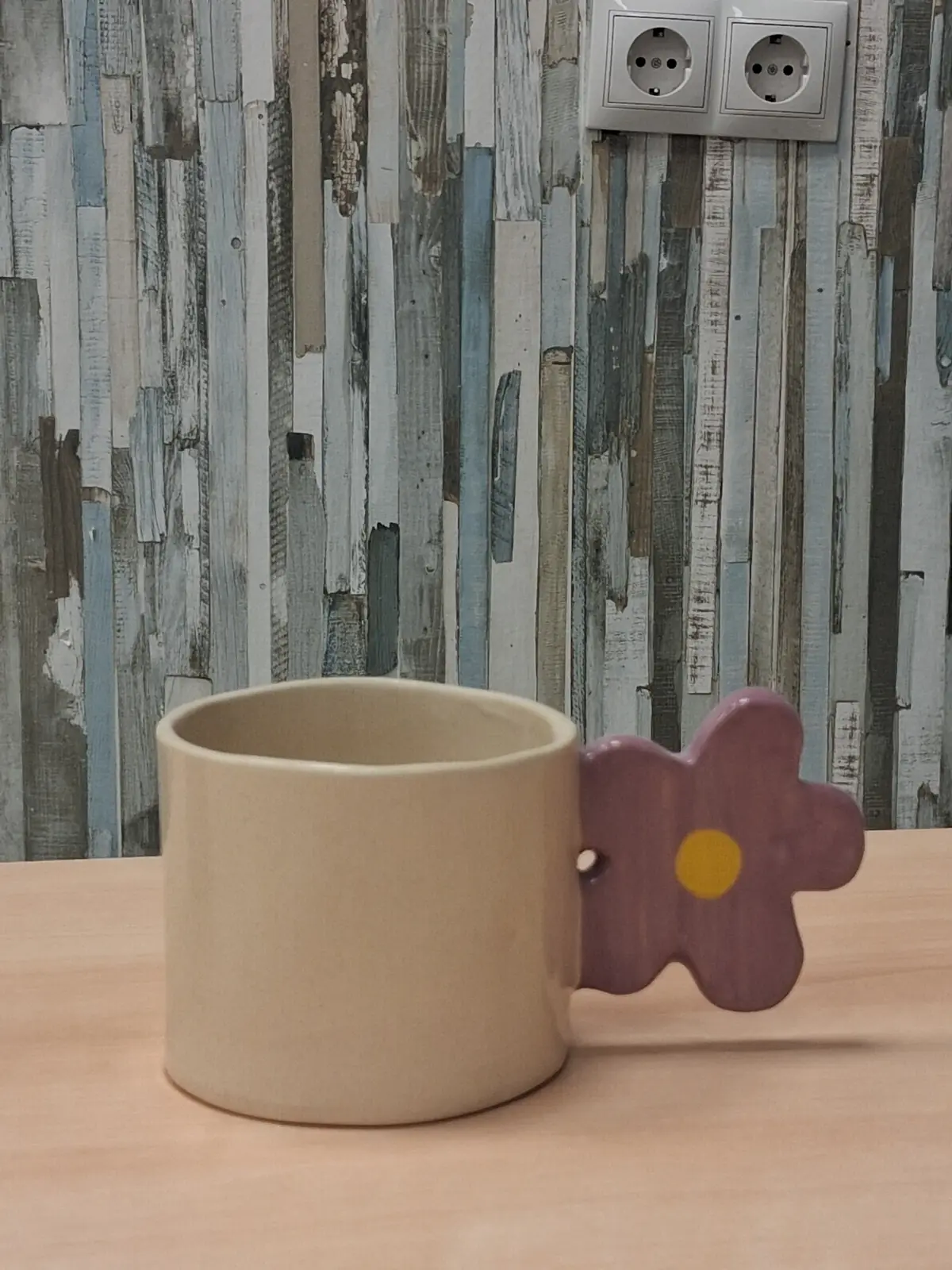 Taza de cerámica con asa en forma de flor hecha en clases semanales de CreArte