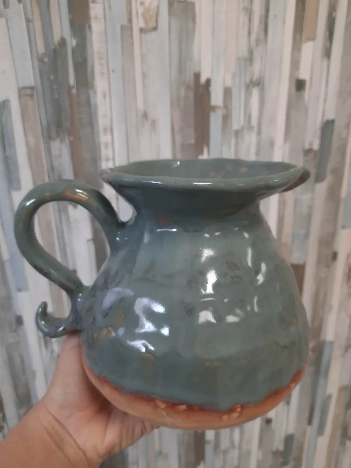 Jarra de cerámica de estilo antiguo con asa y esmalte verde grisáceo hecha en clases semanales de CreArte