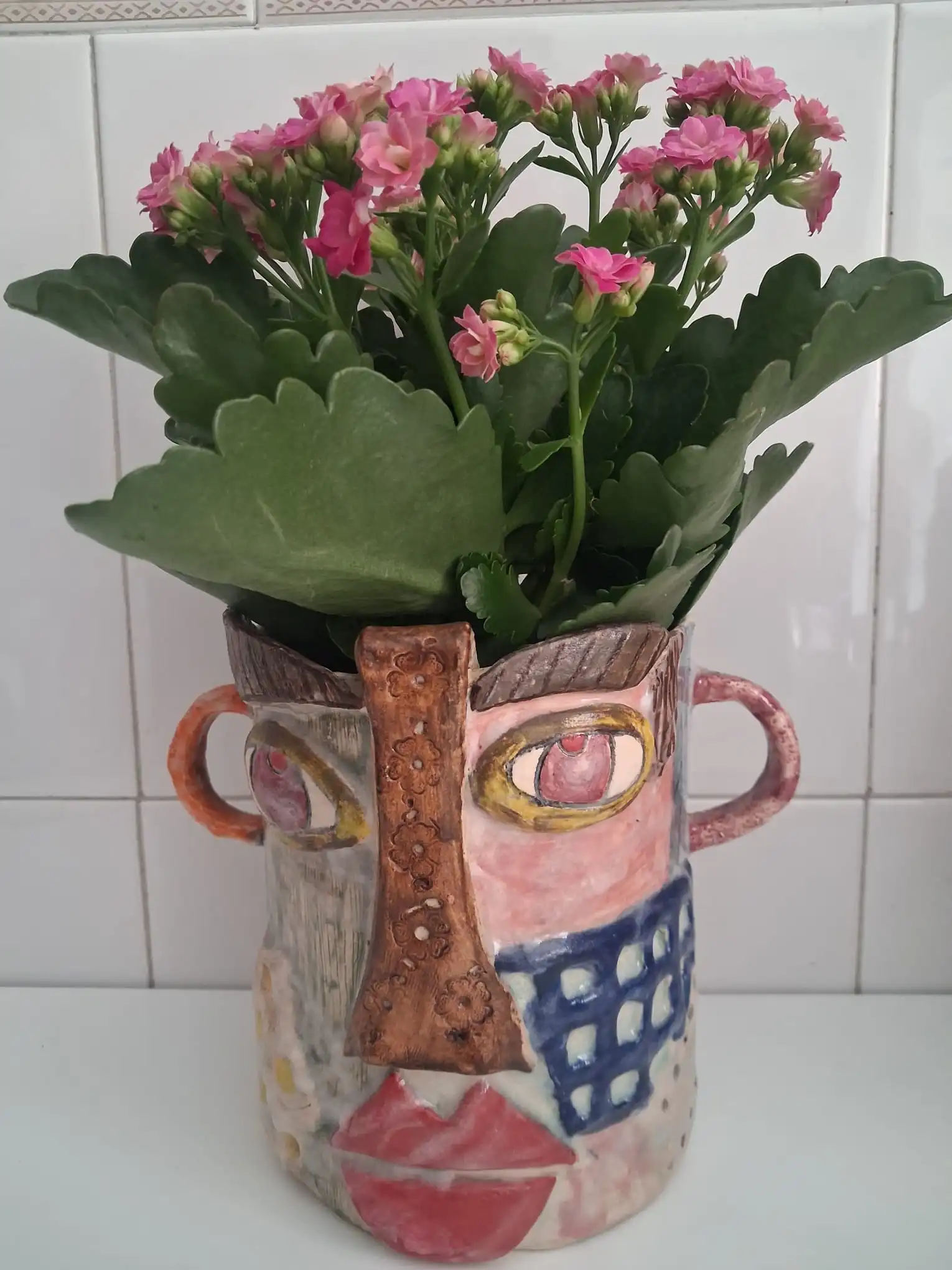 Macetero de cerámica artesanal con forma de cara, decorado a mano y con flores rosas - CreArte Valladolid