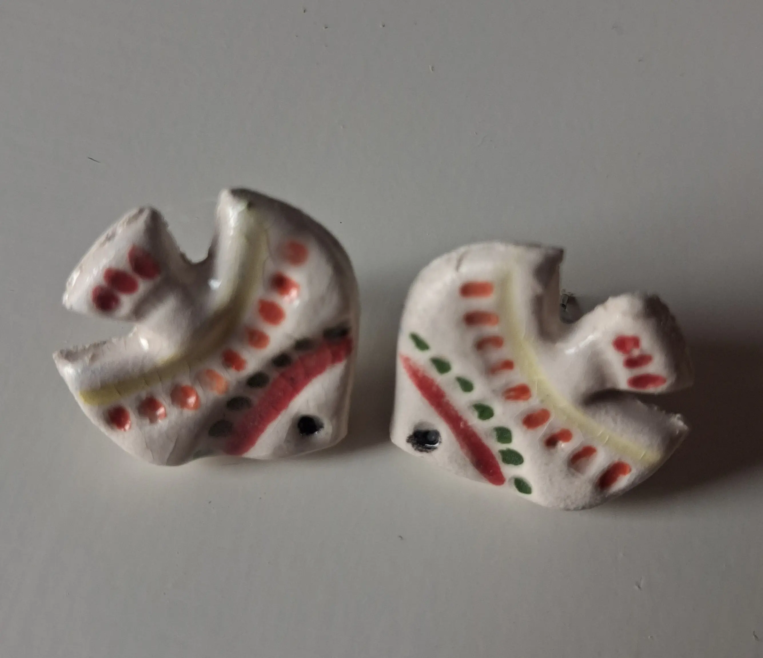 Pendientes de cerámica con forma abstracta y motivos de puntos y rayas en rojo, verde y negro