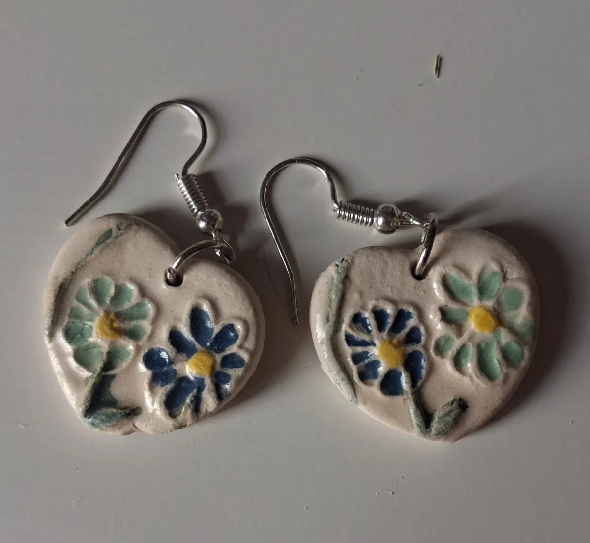 Pendientes de cerámica en forma de corazón con flores azules y verdes pintadas a mano, taller CreArte Valladolid