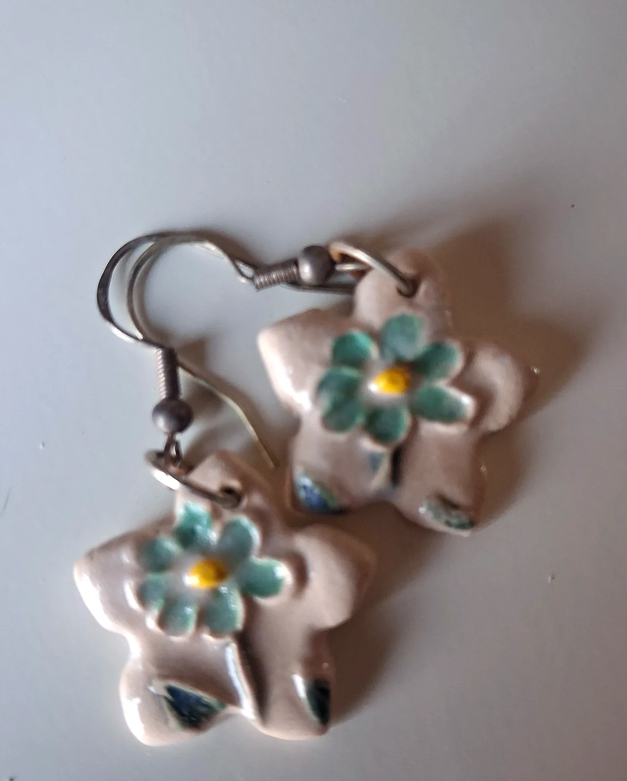 Pendientes de cerámica con forma de flor estrella, base crema con flor verde y centro amarillo pintados a mano