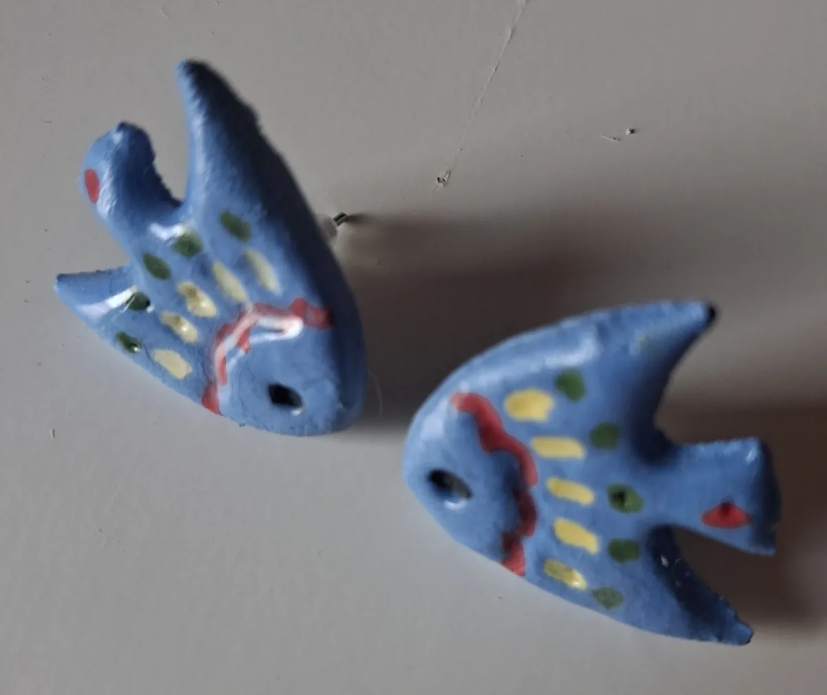 Pendientes de cerámica pintados a mano con forma de pez azul y detalles rojos, verdes y amarillos, taller CreArte Valladolid