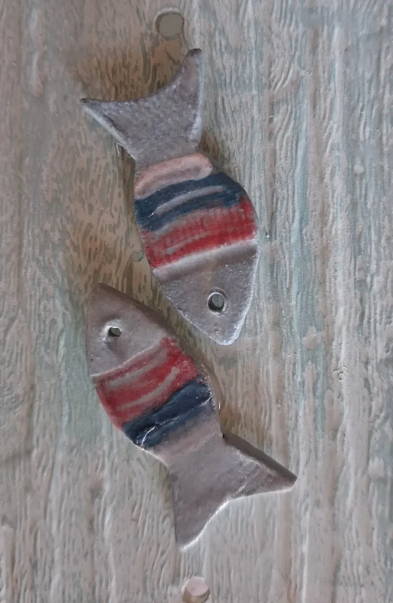 Pendientes de cerámica con forma de pez en tonos grises con detalles rojos y azules