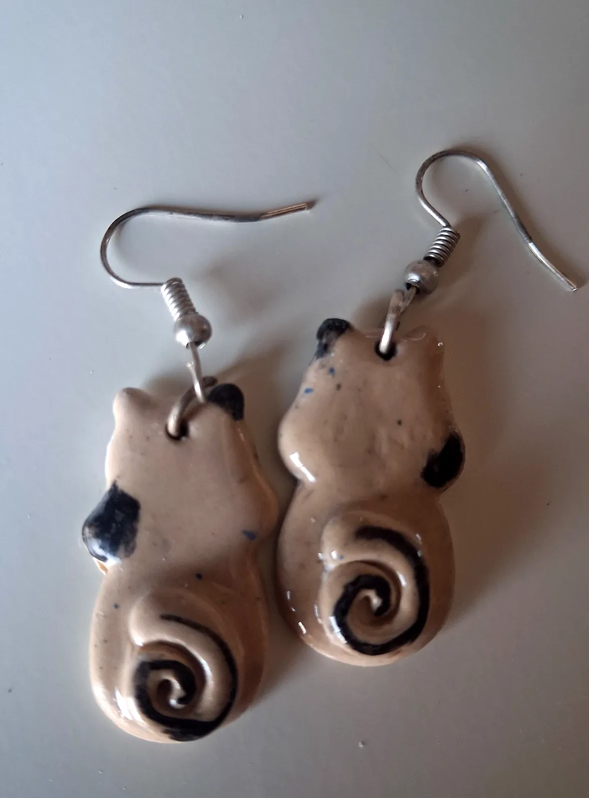 Pendientes de cerámica divertidos con forma de gato y cola en espiral, esmalte crema con manchas negras