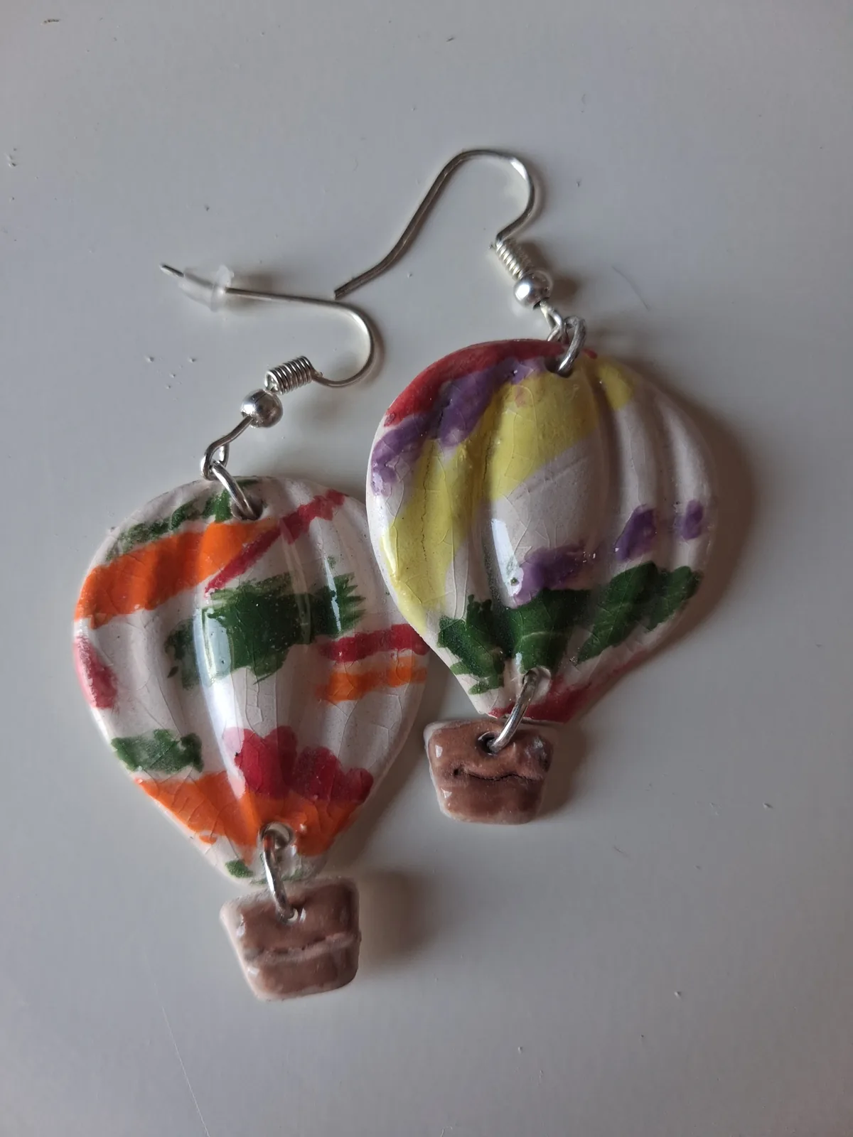 Pendientes especiales de cerámica con forma de globo aerostático, decorados a mano con rayas de colores y cesta de cerámica, taller CreArte Valladolid