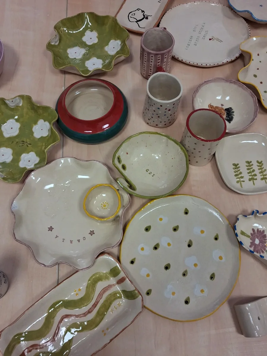 Selección de piezas de cerámica terminadas y esmaltadas por alumnos del taller: platos, cuencos, tazas y bandejas pintadas a mano en distintos colores, CreArte Valladolid