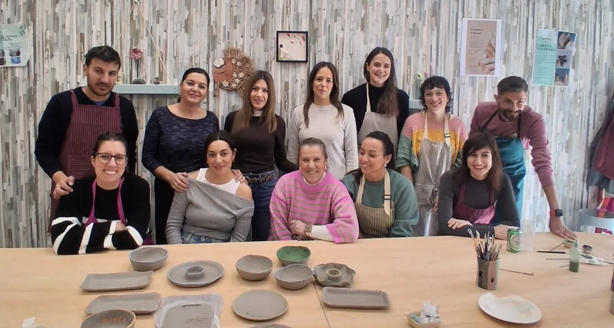 Grupo de amigos y compañeros de trabajo celebrando un evento privado de cerámica en CreArte Valladolid, rodeados de piezas artesanales recién moldeadas