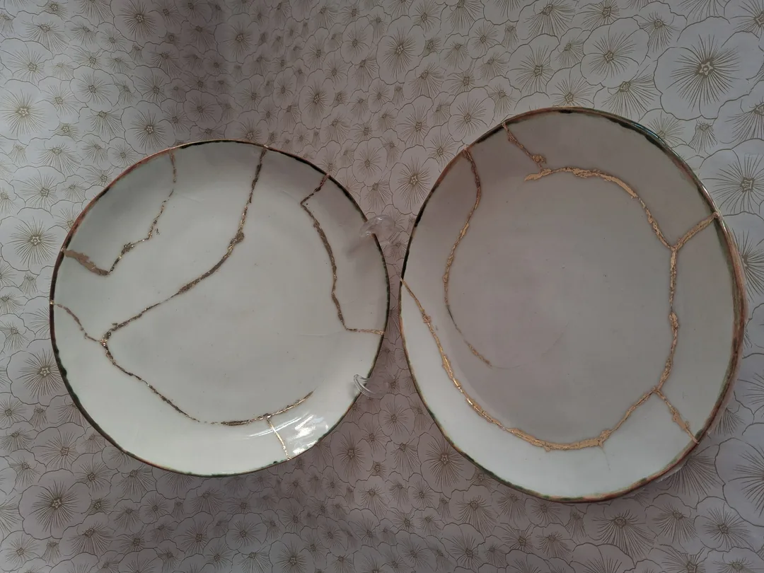 Platos de cerámica reparados con la técnica kintsugi — venas doradas sobre porcelana blanca. CreArte Valladolid