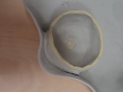 Pieza de cerámica cruda con una unión despegándose en la base, donde la pieza añadida se separa del cuerpo principal, taller CreArte Valladolid